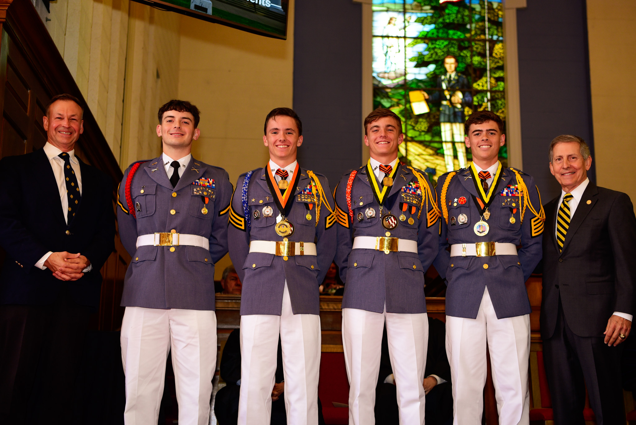 Cadets in dress uniform receiving medals at a formal recognition ceremony